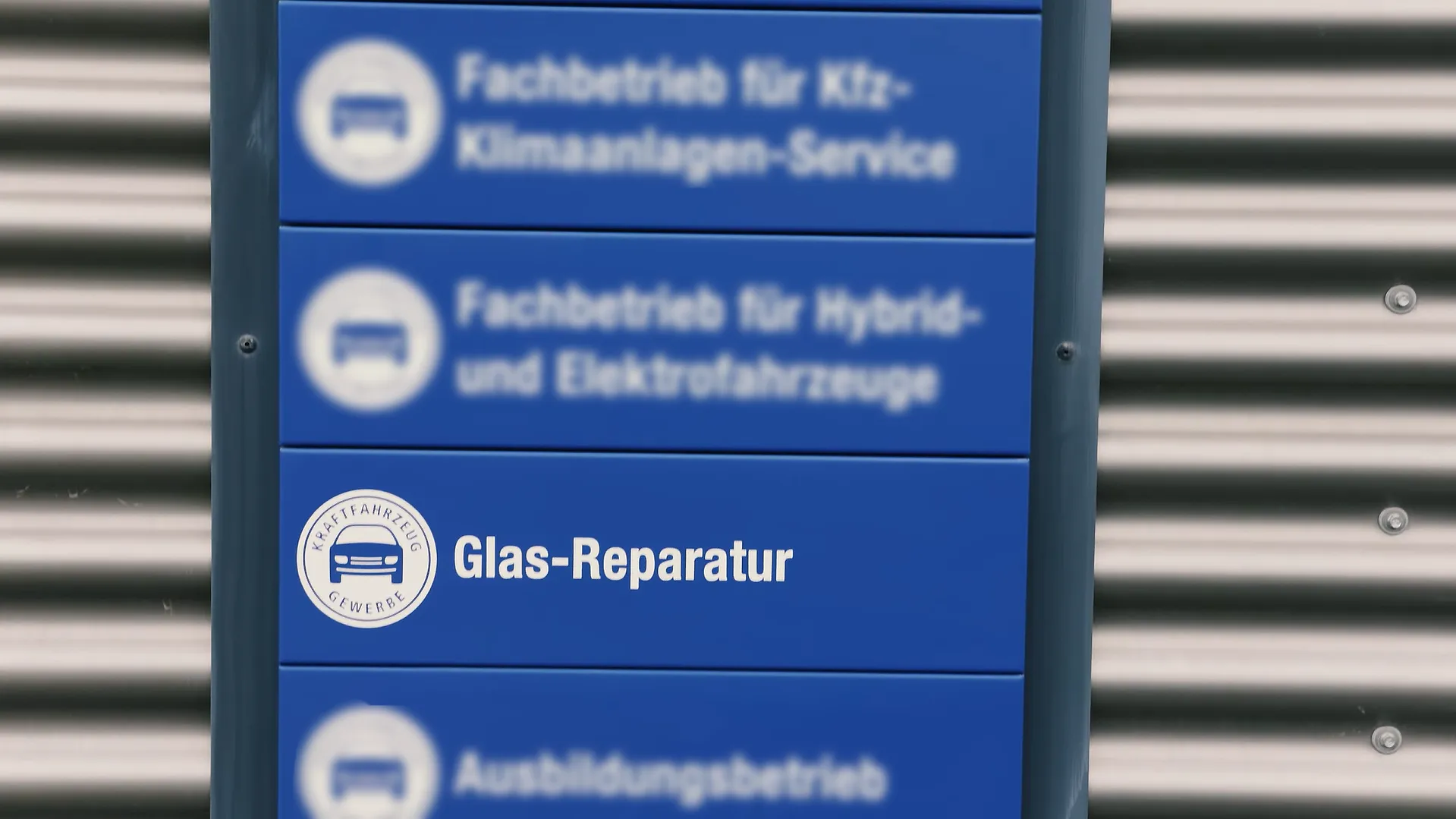 Steinschlag reparieren bei Kfz-Technik Stumpf: Schild „Glas-Reparatur“ an der Werkstatt in Elztal-Dallau